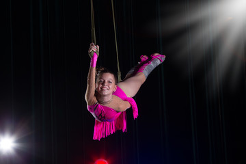 Circus artist acrobat performance. The girl performs acrobatic elements in the air. Circus gymnast on the stage