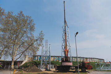 a large crane raises up the reflector structure