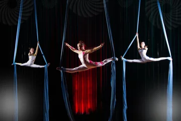Fotobehang Circus actress acrobats performance on canvases. Team girls perform acrobatic elements in the air. © Светлана Лазаренко