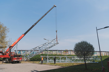 a large crane raises up the reflector structure