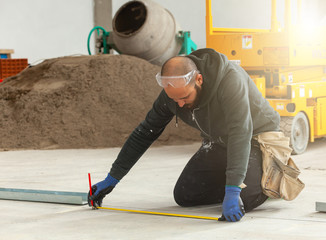 Worker builds a plasterboard wall.