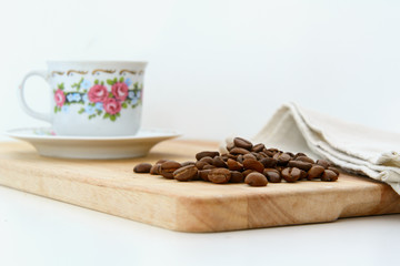 On the kitchen board is a coffee cup with a Chinese pattern, coffee beans and a linen towel. Concept - breakfast with coffee