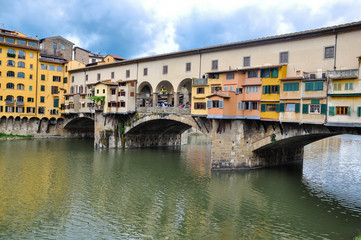 Fototapeta na wymiar Ponte Vecchio or Old Bridge is a medieval stone bridge over the Arno River, in Florence, Italy. It's noted for having shops on in. Photos taken right after the rain as the sun was coming out.
