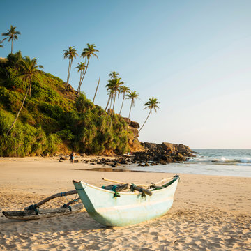 Traditional wooden boat on Talalla Beach at dusk, South Coast, Sri Lanka, Asia