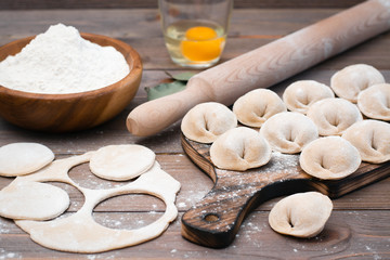 Fototapeta na wymiar The process of molding dumplings and ingredients for cooking on a wooden table