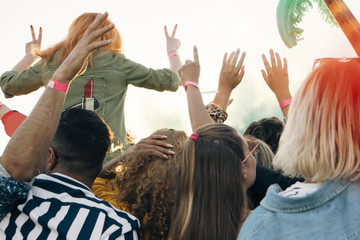 Rear view of enthusiastic fans enjoying in music concert during sunny day