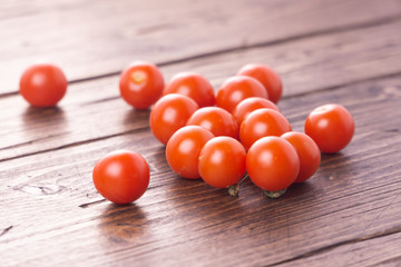 Fresh ripe garden tomatoes lying on wooden table. Side view with copy space.