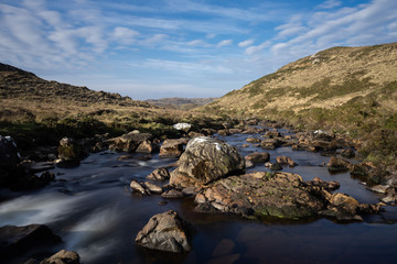 Fototapeta na wymiar des rochers au milieu d'une rivière et du courant