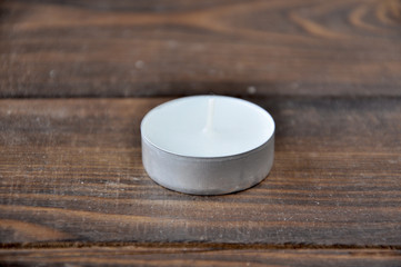 a small candle stands on a wooden table
