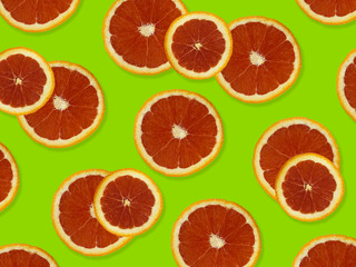 Creative pattern made of red oranges. top view of colorful fruit pattern of fresh red orange slices on green colorful background. 