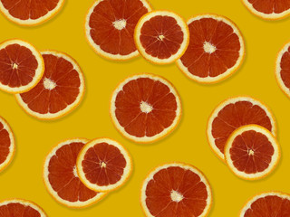 Creative pattern made of red oranges. top view of colorful fruit pattern of fresh red orange slices on yellow colorful background. 
