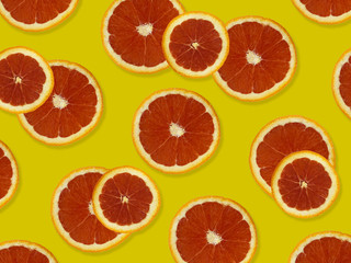 Creative pattern made of red oranges. top view of colorful fruit pattern of fresh red orange slices on yellow colorful background. 