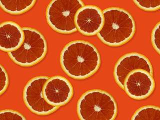 Creative pattern made of red oranges. top view of colorful fruit pattern of fresh red orange slices on orange colorful background. 