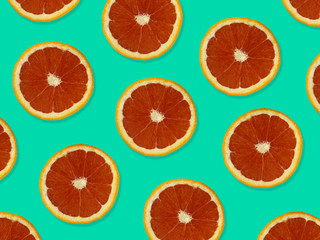 Creative pattern made of red oranges. top view of colorful fruit pattern of fresh red orange slices on blue colorful background. 