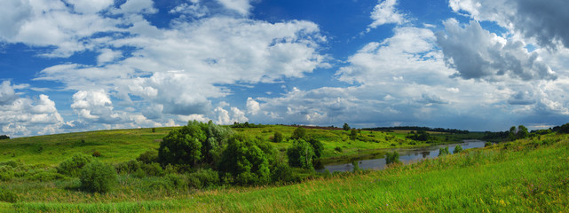 Sunny summer landscape with river and green hills
