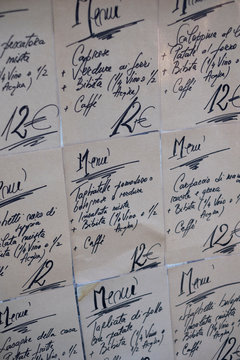 Close up of handwritten set menus on the wall at an Italian restaurant.