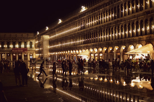 Illuminated facade of the Procuratie Nuove in St Marks Square in Venice, Veneto, Italy, at night.