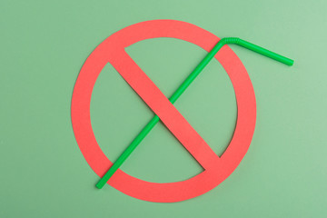 No plastic. Green plastic straw set up in a red prohibition circle over a green background, telling...