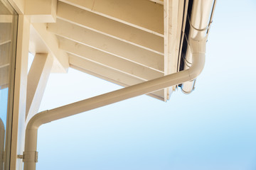 Gutter on house corner. Metal eave on roof