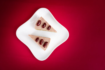 Sliced of Red bean cheese cake on white plate on red Background.