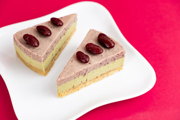 Sliced of Red bean cheese cake on white plate on red Background.