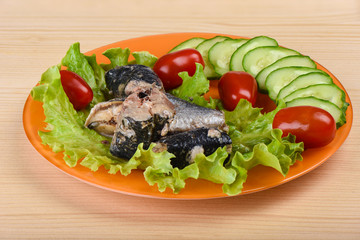 Pieces of sardine iwashi on lettuce leaves with red tomatoes.