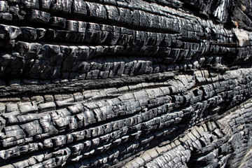 Side wooden wall of an old house after a fire