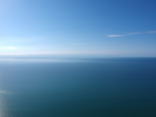 Obraz premium Seascape with sea horizon and clear deep blue sky. Horizontal vivid minimal landscape abstraction background backdrop. Get lost in a peaceful and misty ocean aerial view.