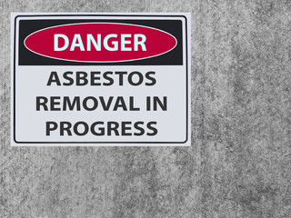 the sticker Sign danger asbestos removal on the plaster asbestos wall