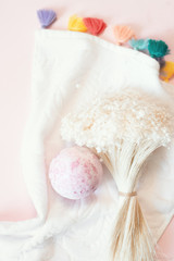 Natural cosmetics. Bath bomb, flowers and towel on pink pastel background