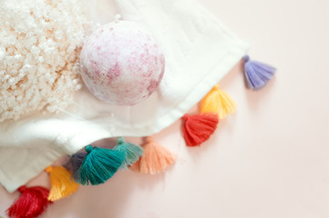 Natural cosmetics. Bath bomb, flowers and towel on pink pastel background
