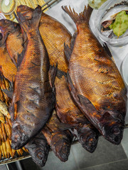 Beautiful brown-golden smoked fish. Close-up of smoked fish. Various lake or sea fish. Tasty and...