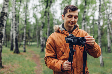 Videographer filming spring forest. Man using steadicam and camera to make footage. Video shoot