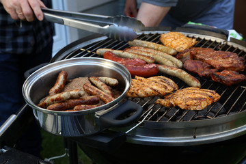 Meat and sausages are fried on the grill
