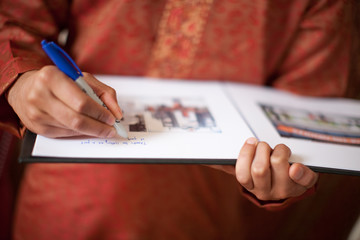 Person signing guestbook at Indian wedding - obrazy, fototapety, plakaty