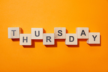 top view of wooden blocks with letters on orange surface