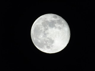 Genova, Italy - 03/22/2019: An amazing photography of the full moon over the city of Genova by night with a great clear sky in background and some stars