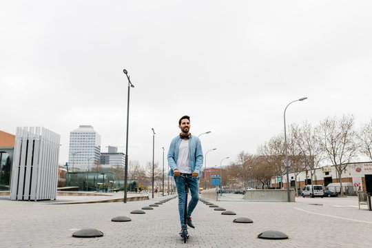Man commuting in the city, using his kickboard