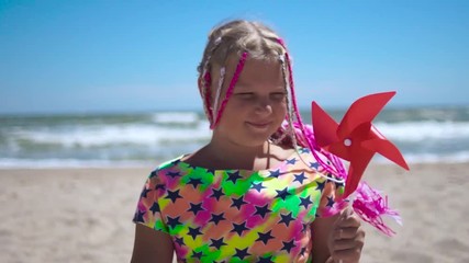 A girl holds a toy windmill in her hands