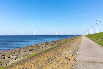 Scenic view of windmills on sea coast in Noordoostpolder, Netherlands