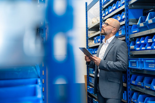 Businessman With Tablet In Factory Storehouse