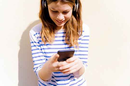 Young woman with headphones using smartphone