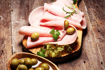 Sliced ham on wooden background. Fresh prosciutto. Pork ham proscuitto sliced.