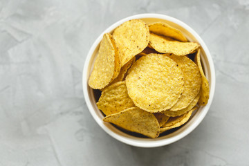 Tortilla corn chips in bowl an a gray background