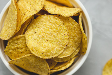 Tortilla corn chips in bowl an a gray background