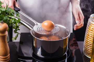 young woman in an gray apron boiled eggs