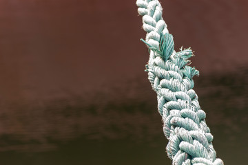 A big rope of the ship on the metal it is a knot rope that holds the ship in dock