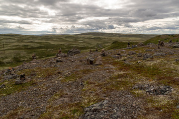 Stones stacked for Norwegian fairytale trolls. Relief and texture of stone with patterns and moss. Stone natural background. Stone with Moss. Stones boulders covered with moss.
