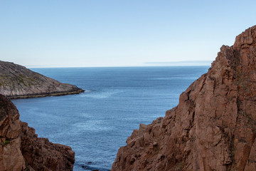 river meets ocean along a rocky shoreline with heavy water flow in a forest area, Motion river