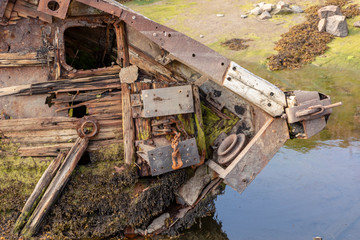 Fototapeta na wymiar old shipwreck or abandoned shipwreck, broken fishing ship lies on its side near the shore